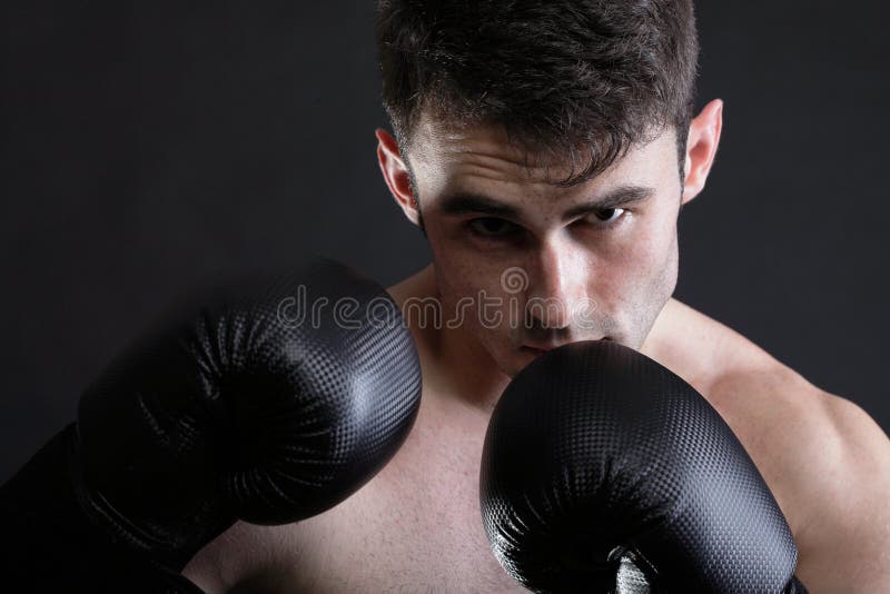 Fotografía oscura de niños entrenando con un gran saco de boxeo en