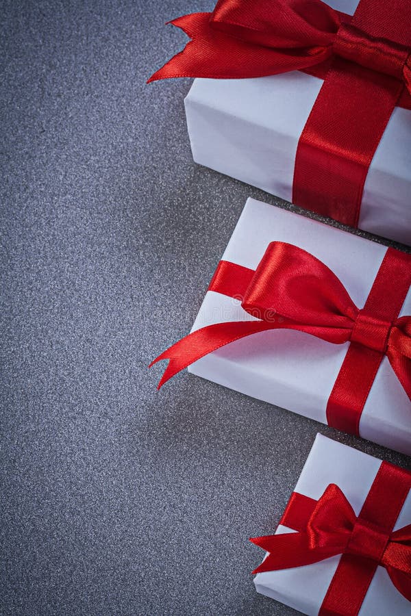 Boxed Gifts with Tied Red Bows on Grey Surface Holidays Concept Stock