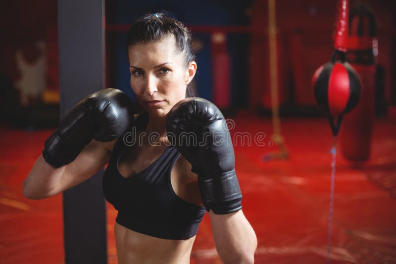 Boxeur féminin sûr exécutant la position de boxe photographie stock Boxeur féminin sûr exécutant la position de boxe photographie stock