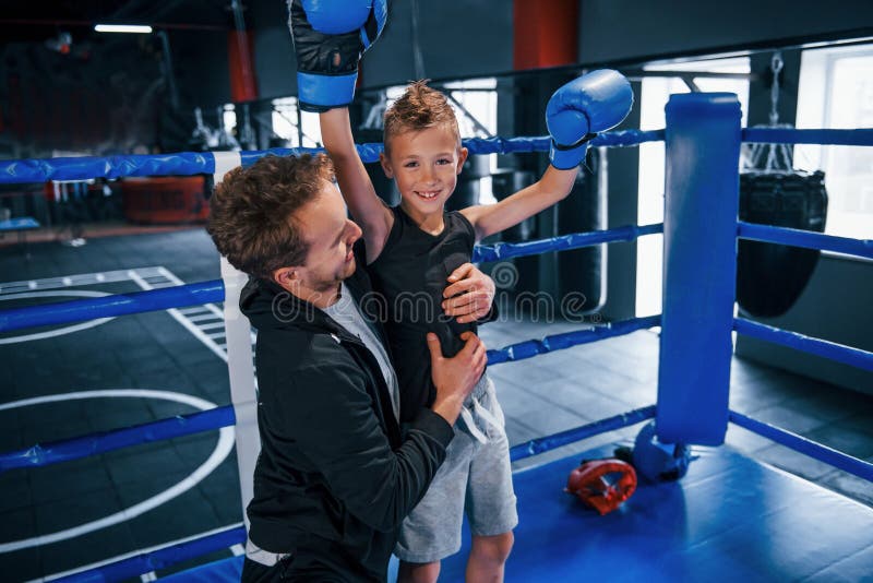 Boxing Coach Standing in the Ring with Boy and Celebrating Victory
