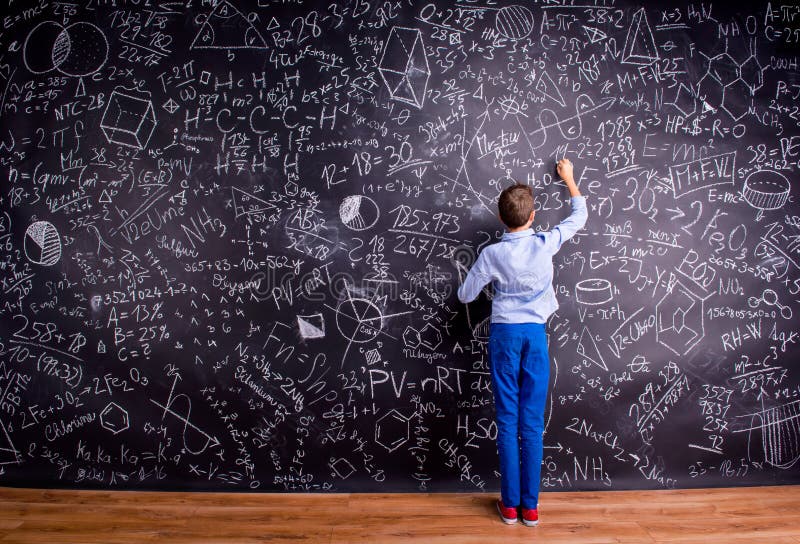 Boy against big blackboard with mathematical symbols and formula