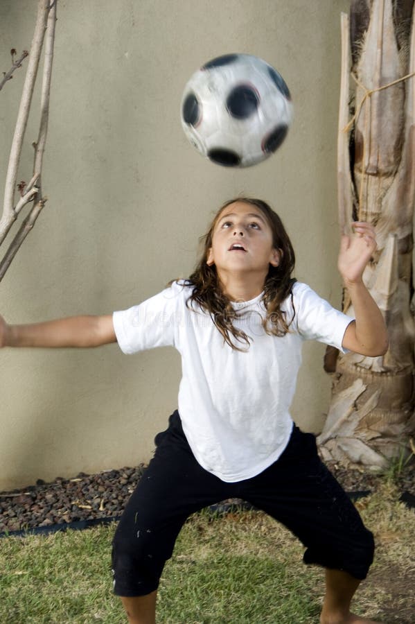 Boy balancing football on his head