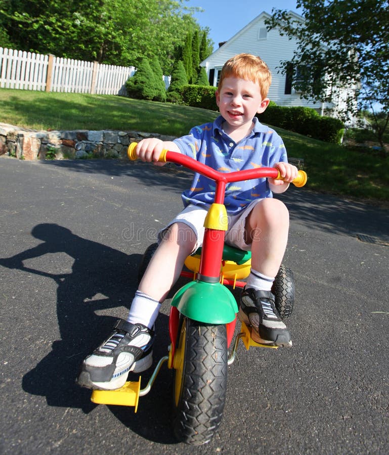 Happy young boy playing outside on a bike. Happy young boy playing outside on a bike