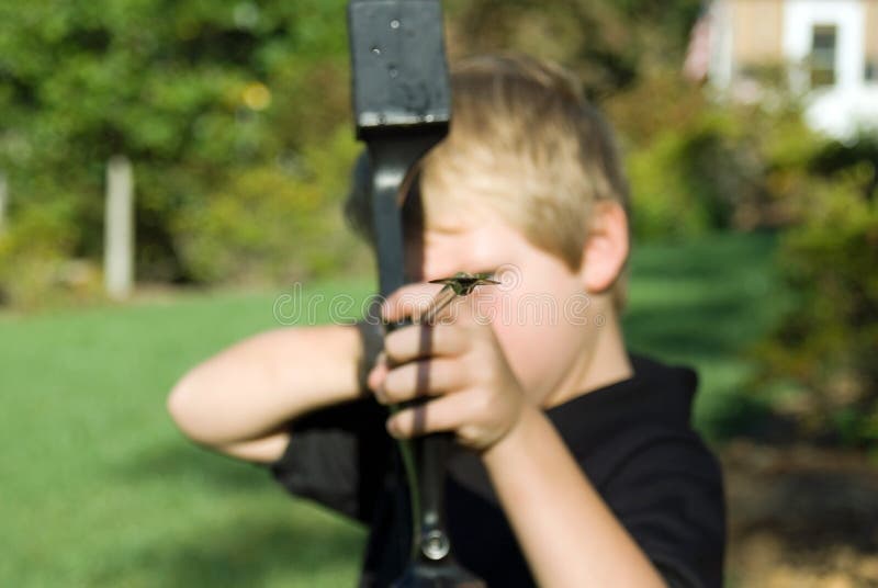 Young boy with a bow and arrow learning to shoot. Young boy with a bow and arrow learning to shoot.