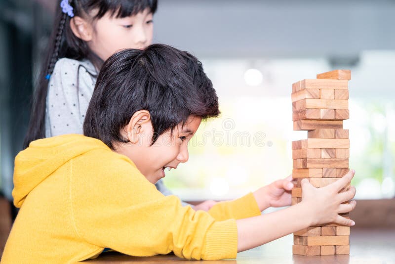 Boy building toy block tower with friend