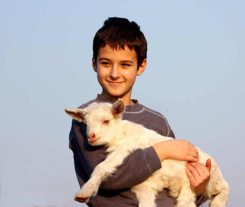 A boy carry a baby goat