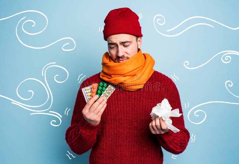 Boy caught a cold and uses pills to heal. Studio on Cyan background royalty free stock image Boy caught a cold and uses pills to heal. Studio on Cyan background royalty free stock image