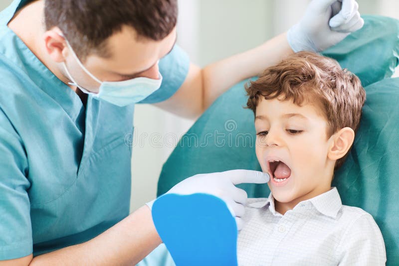 Boy child and dentist are checking teeth in the mirror. royalty free stock photos Boy child and dentist are checking teeth in the mirror. royalty free stock photos