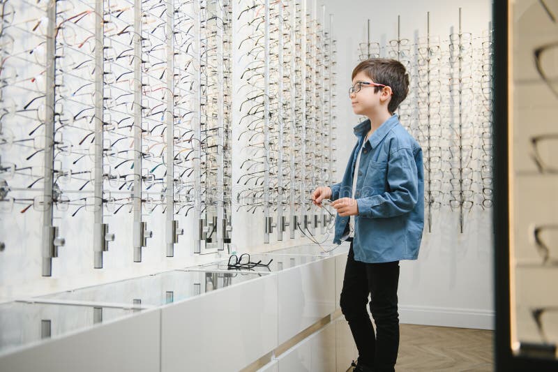 Boy Choosing Glasses in Optics Store. Stock Photo Image of woman