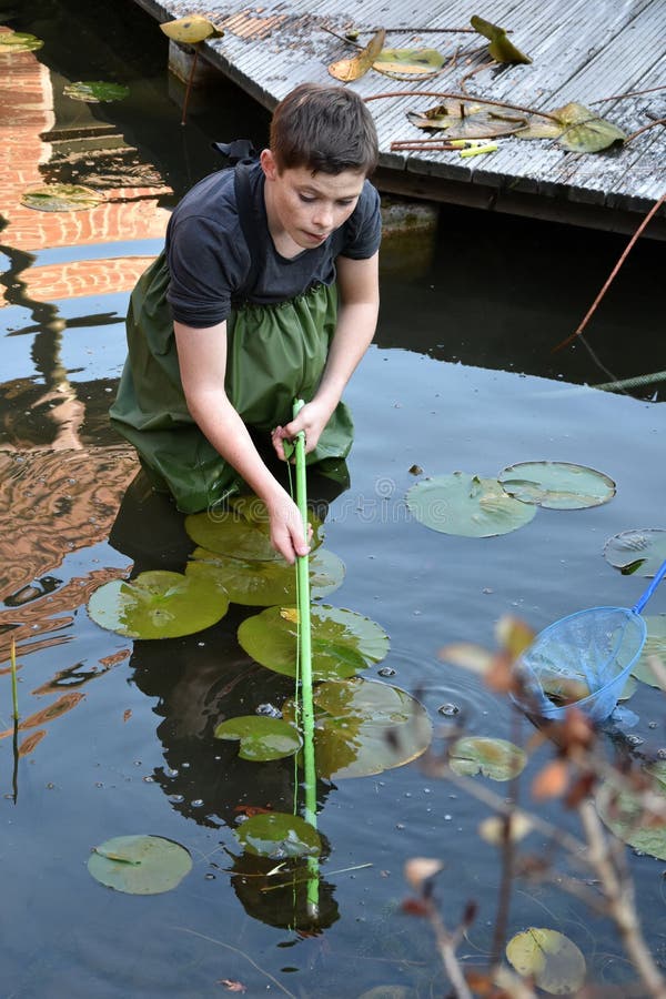 Boy cleaning garden pond