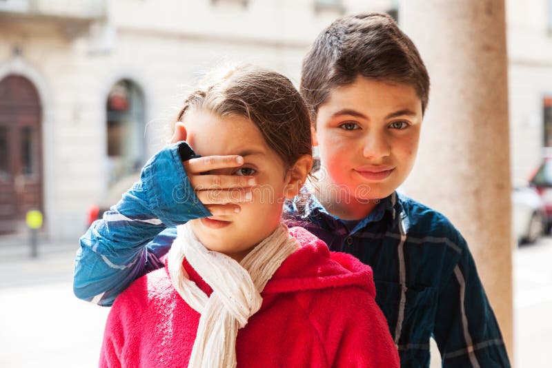 Boy covers eyes of his sister, portrait stock photos Boy covers eyes of his sister, portrait stock photos