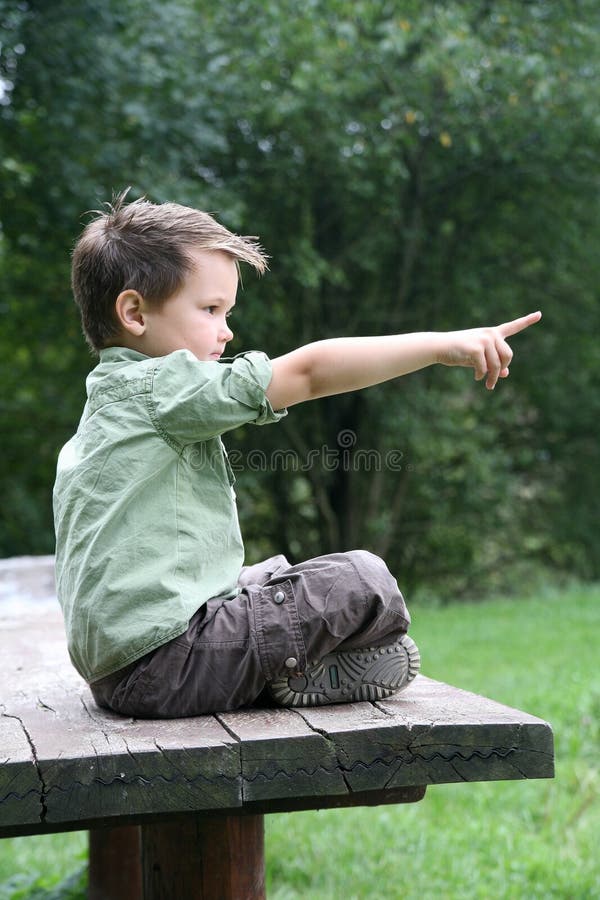 Boy cross-legged on a wooden bench stock images Boy cross-legged on a wooden bench stock images