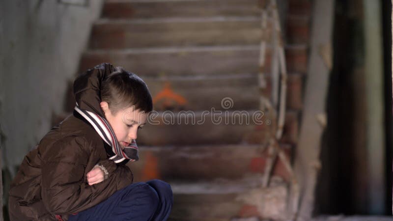 Boy in depression, hiding from the cold in an old dilapidated house royalty free stock photography Boy in depression, hiding from the cold in an old dilapidated house royalty free stock photography