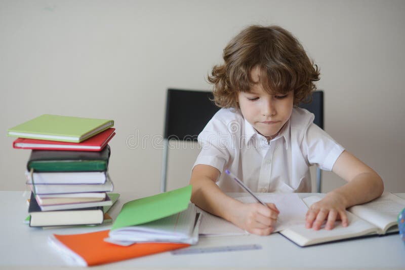 Boy Makes Homework Sitting On Stack Of Books Stock Photo ...
