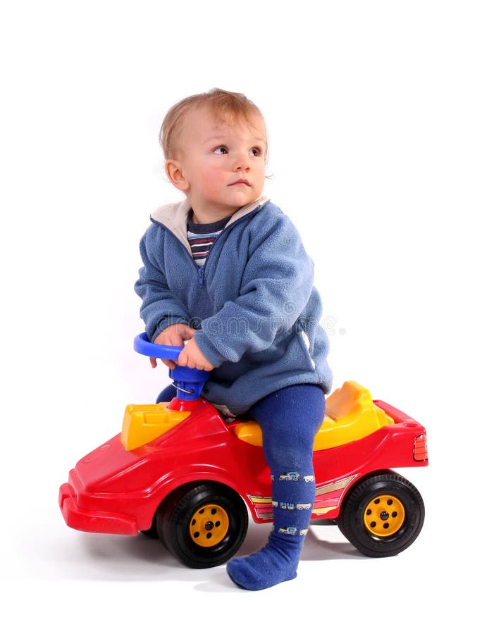 Boy driving a red toy car