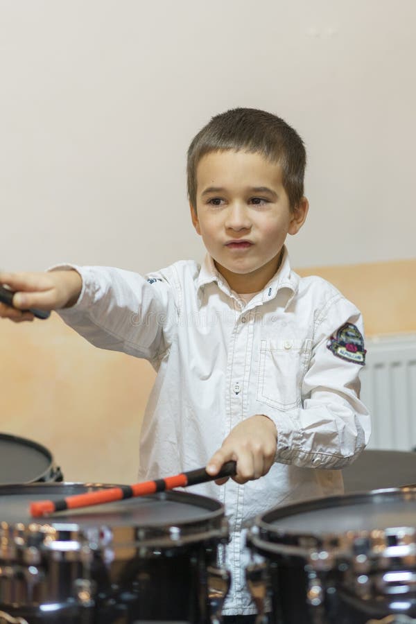 Boy Drumming. Boy in a White Shirt Plays the Drums. a Boy in a White