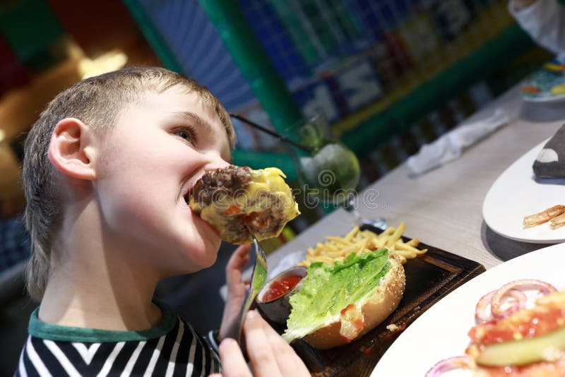 Boy eating burger stock photo. Image of healthy, hunger 140601374