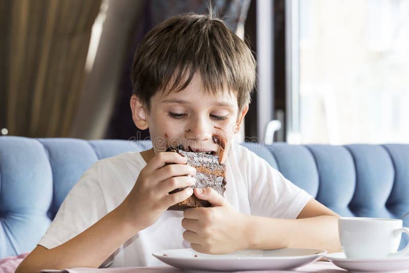 The Boy is Eating a Large Piece of Cake Stock Image Image of casual, happiness 99245305