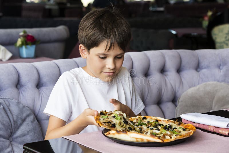 The boy is eating pizza stock image. Image of face, cafe 97603885