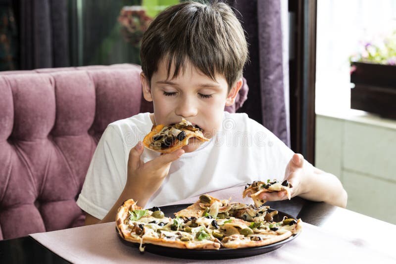 The boy is eating pizza stock image. Image of hair, hungry 97604345