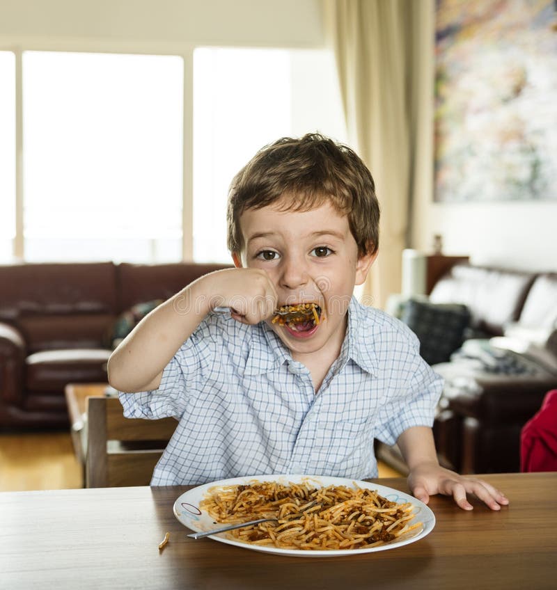 Boy eating spaghetti stock photo. Image of breakfast 102601460
