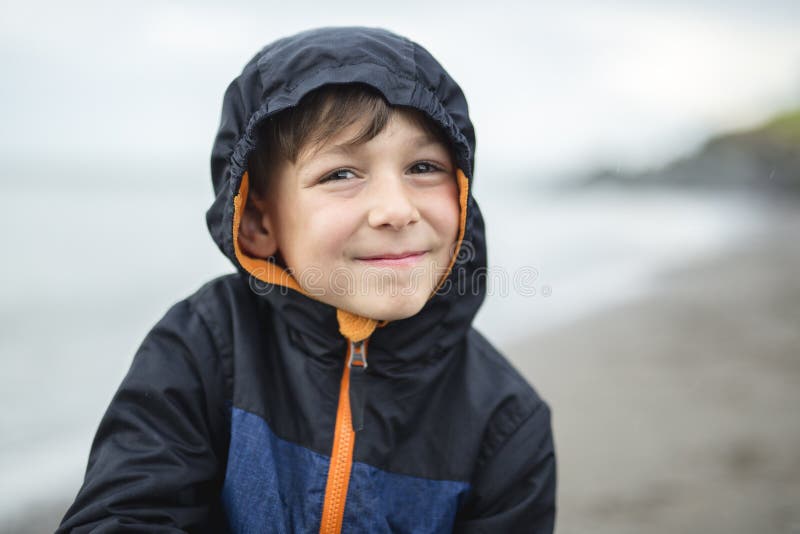 Boy Enjoying The Rain And Having Fun Outside On The Beach A Gray Rainy Stock Photo Image of