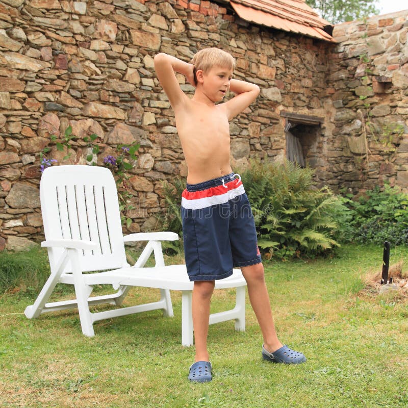 Boy exercising in front of garden lounger