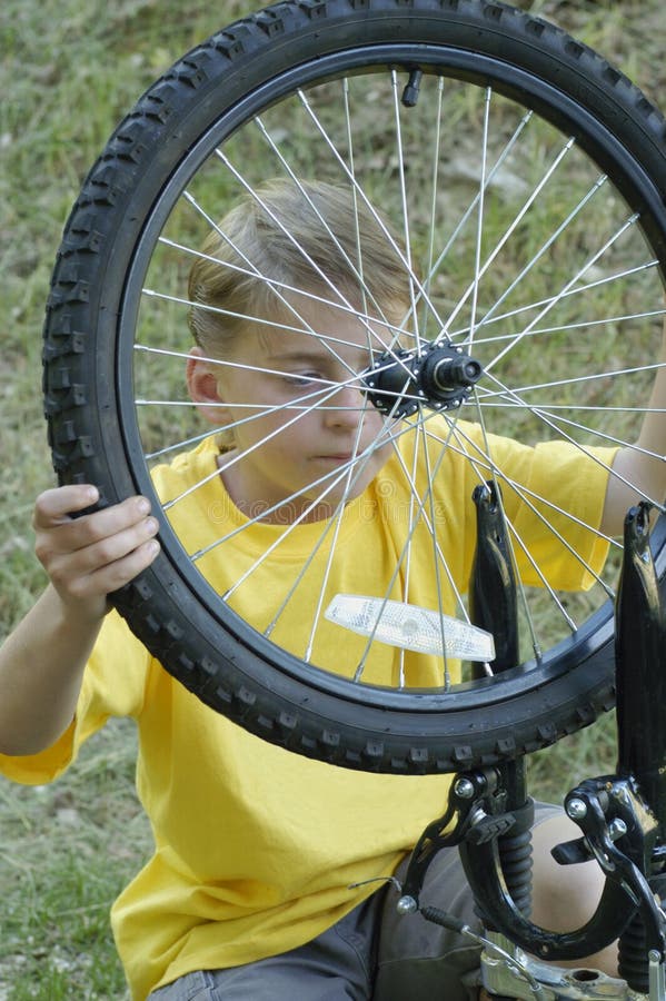 Boy fixing bike wheel stock photo. Image of tire, spokes 2528764
