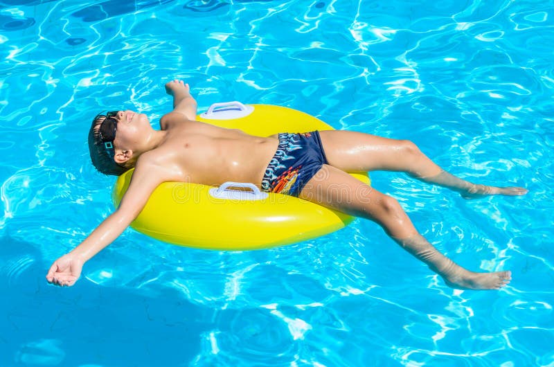 Boy floating on an inflatable circle in the pool.