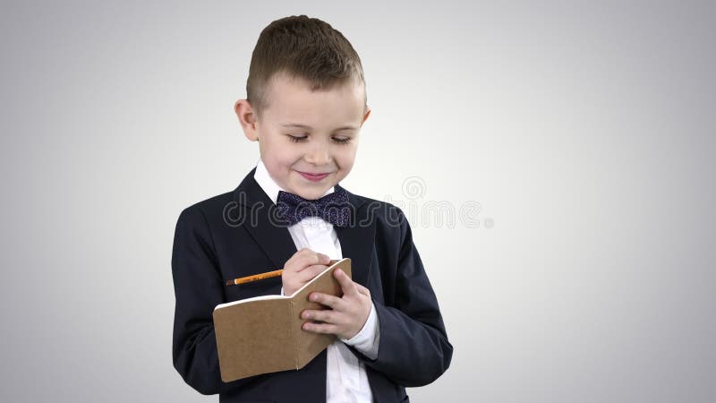 Boy in a formal clothes writing in check list or notebook on gradient background.