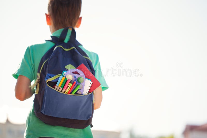 Boy with full school backpack. Little pupil going back to school. Back view stock images