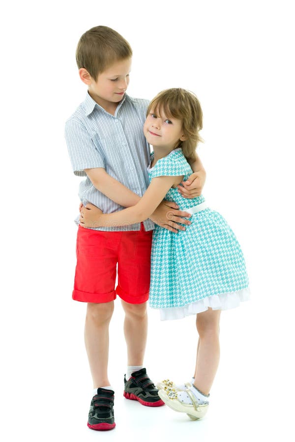 Charming little girl hugging a tall boy with blond hair. 