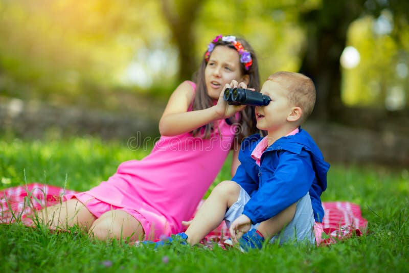 Boy and girl exploring the environment with a binocular stock image