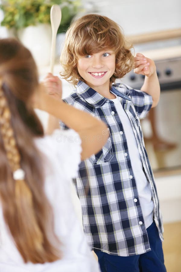 Boy and girl fighting in jest in kitchen