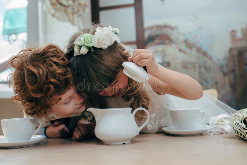 Boy and girl having tea party in cafe