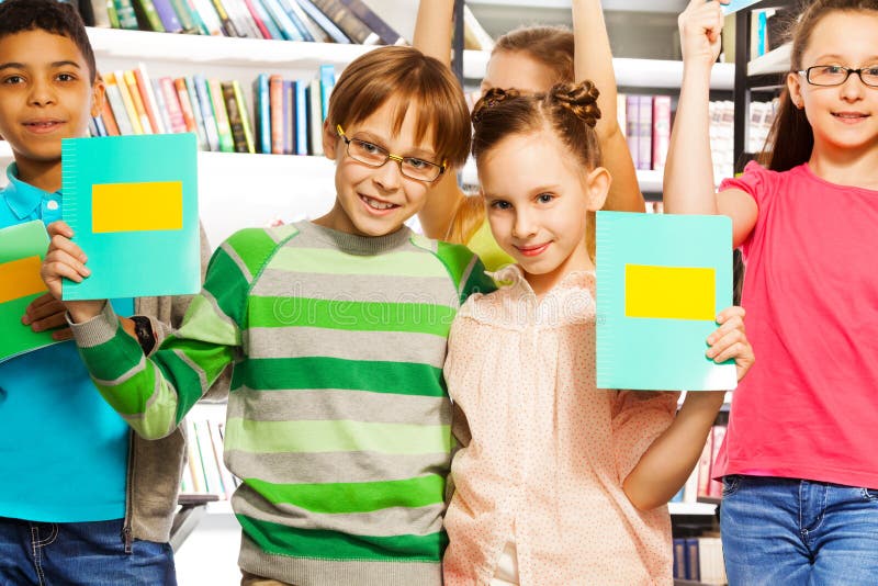 Boy and girl hold exercise books in library