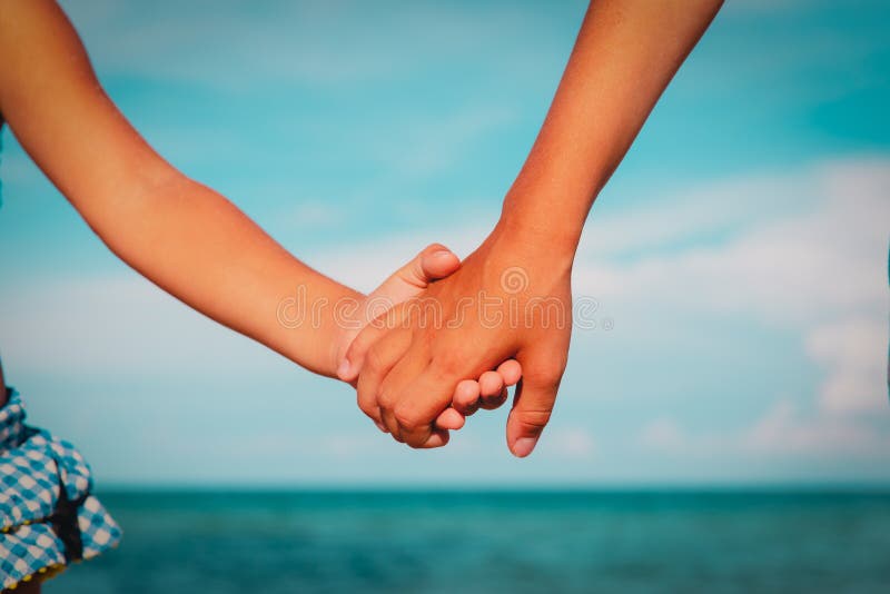 Boy and girl holding hands at sea, frendship and care