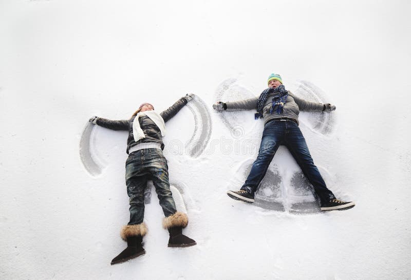 Boy and girl making snow angels