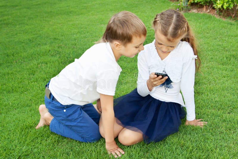 Boy and girl playing on a mobile phone