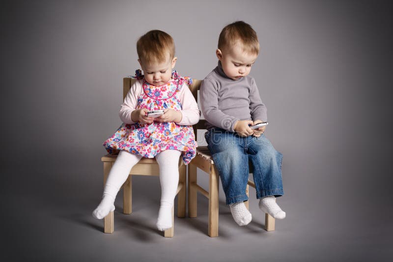 Boy and girl playing with mobile phones