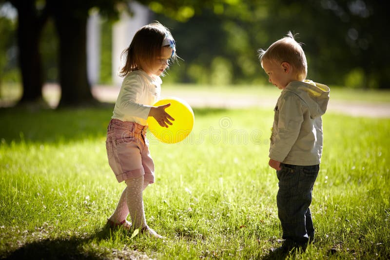 Boy and girl playing with yellow ball