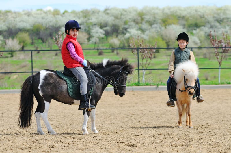 Boy and girl riding ponies