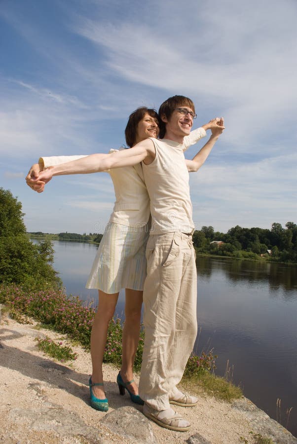 Boy and girl on the river`s bank