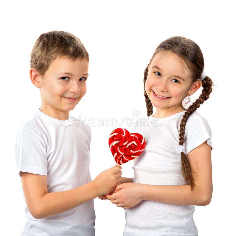 Boy gives a little girl candy lollipop heart isolated on white. Valentine`s day. Kids love.