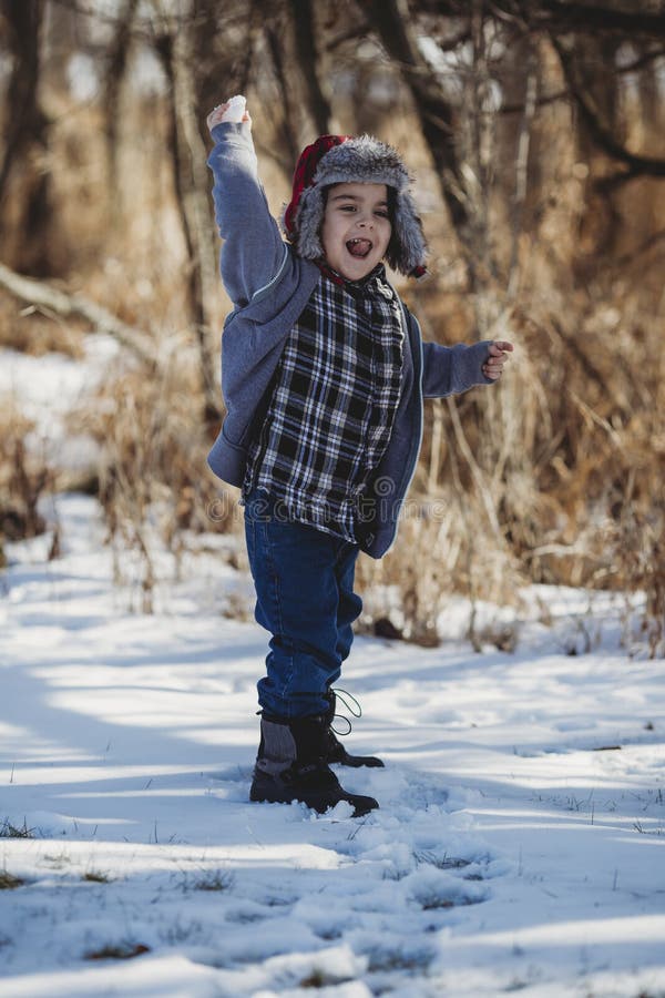 Boy In Gray Jacket And Blue Jeans Standing On Snow Outdoor Picture