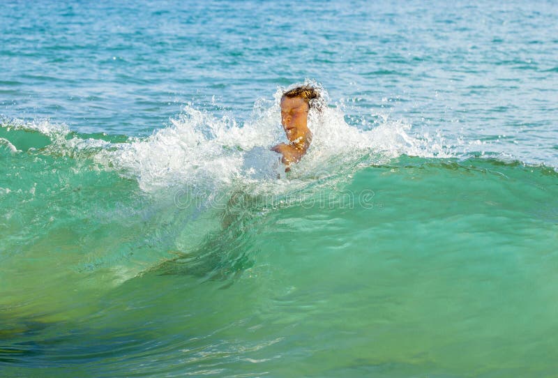 Boy has fun jumping in the waves