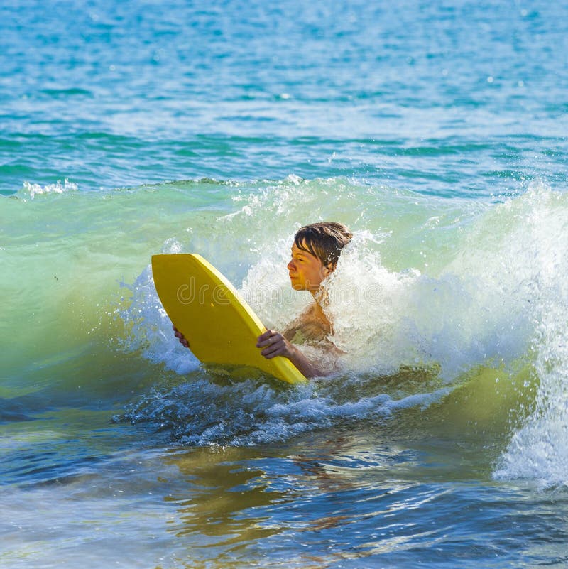 Boy has fun surfing in the waves