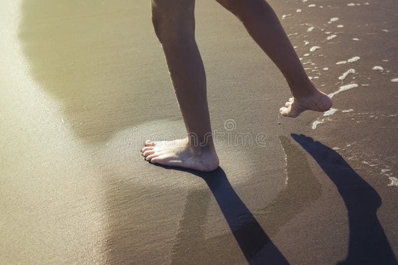 The Boy is Having Fun and Leaves Footprints on the Sand. Stock Photo Image of sand, play