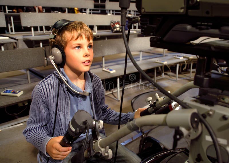 Boy with headphones sits on video camera