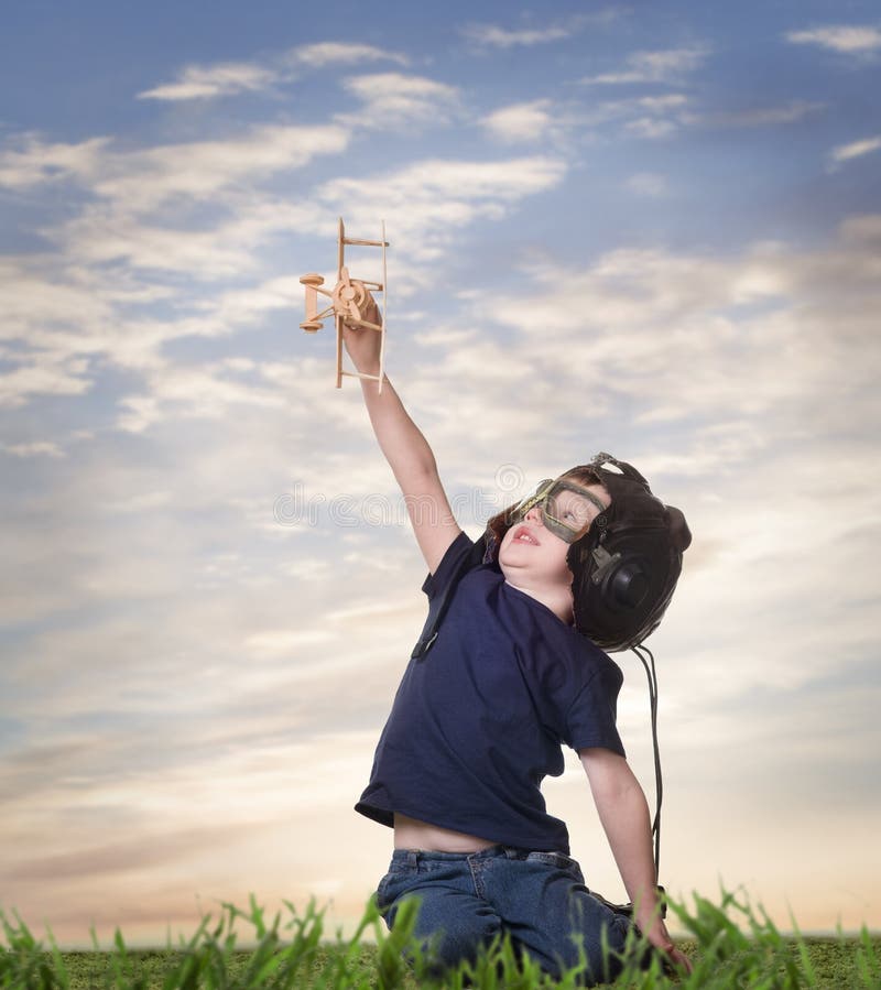 Boy in helmet pilot playing with a airplane